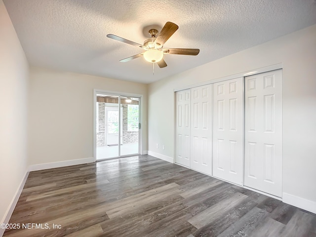 unfurnished bedroom with a textured ceiling, ceiling fan, dark hardwood / wood-style floors, and access to outside