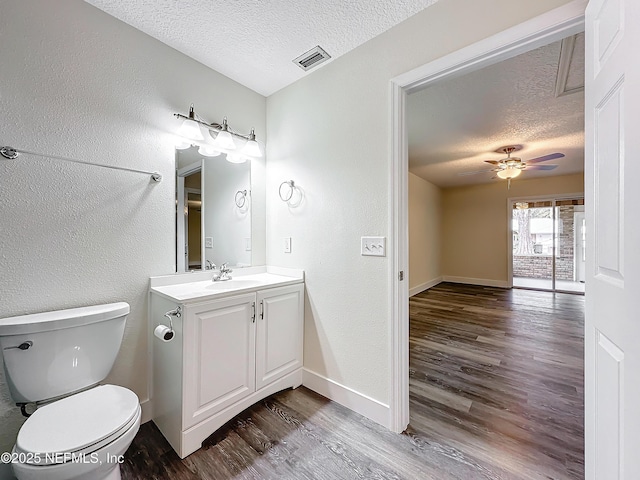 bathroom featuring a textured ceiling, ceiling fan, wood-type flooring, and toilet