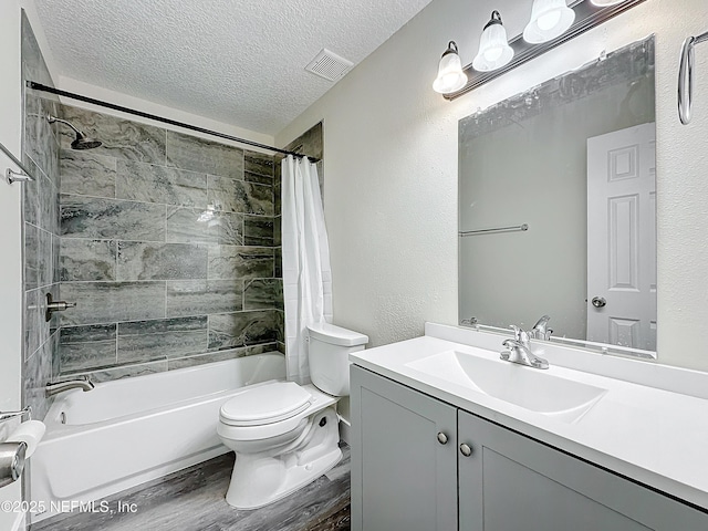 full bathroom with toilet, vanity, hardwood / wood-style floors, a textured ceiling, and shower / bath combo with shower curtain