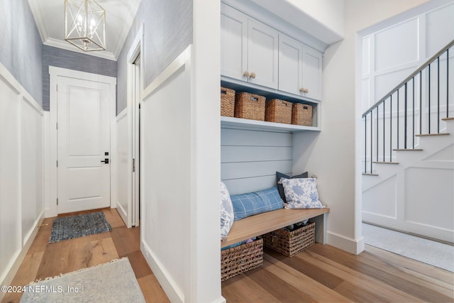 mudroom with light hardwood / wood-style floors, ornamental molding, and a chandelier