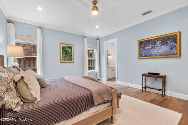 bedroom with light wood-type flooring, ceiling fan, crown molding, and connected bathroom