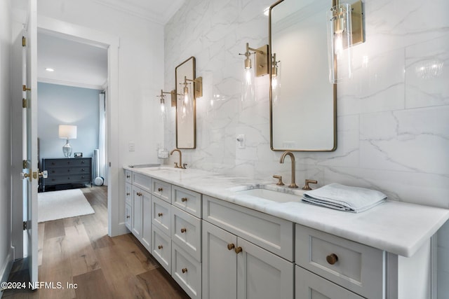 bathroom featuring vanity, tile walls, ornamental molding, and hardwood / wood-style floors