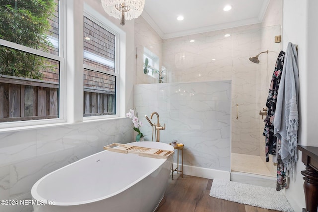 bathroom featuring hardwood / wood-style floors, a notable chandelier, independent shower and bath, tile walls, and crown molding