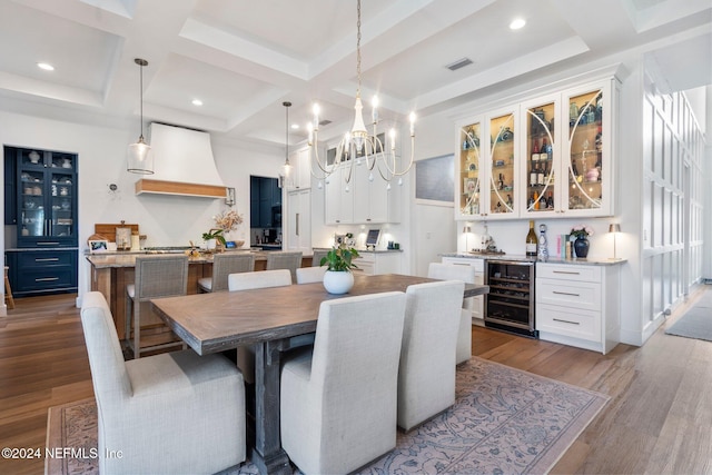 dining room featuring wine cooler, a notable chandelier, beamed ceiling, coffered ceiling, and light wood-type flooring