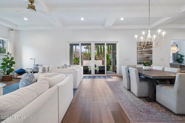 dining room featuring beam ceiling, wood-type flooring, a wealth of natural light, and ceiling fan with notable chandelier