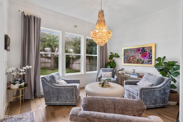 living room featuring an inviting chandelier, a healthy amount of sunlight, hardwood / wood-style floors, and crown molding