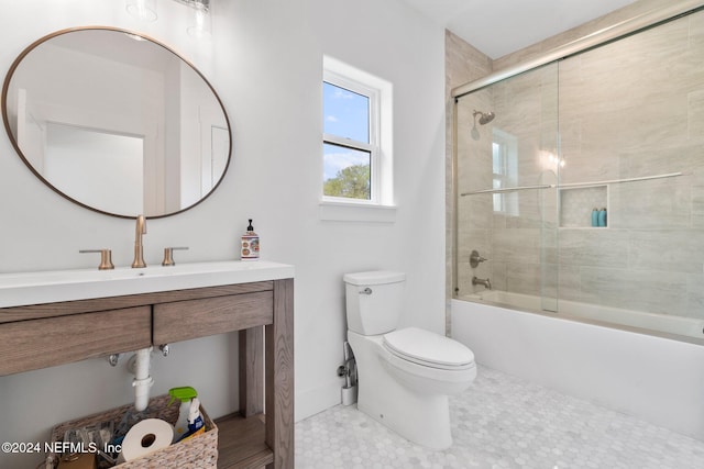 full bathroom featuring toilet, bath / shower combo with glass door, and vanity