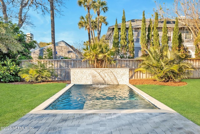 view of pool featuring pool water feature, a patio area, and a yard