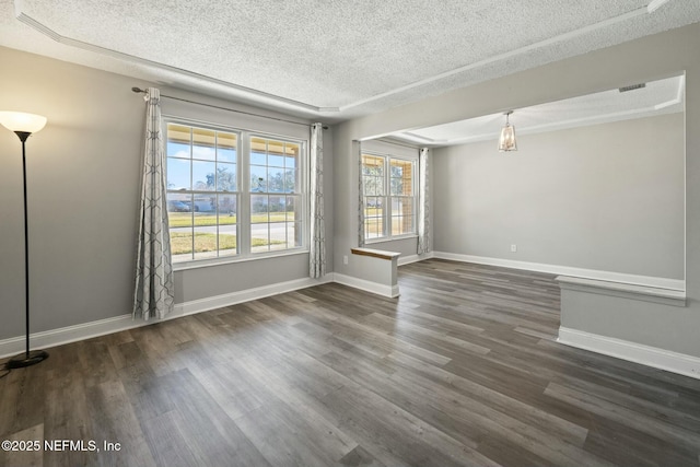 empty room with a textured ceiling and dark hardwood / wood-style flooring