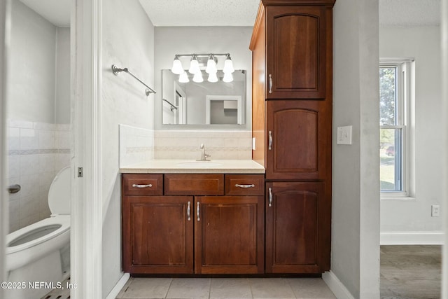 bathroom featuring toilet, vanity, plenty of natural light, and a textured ceiling