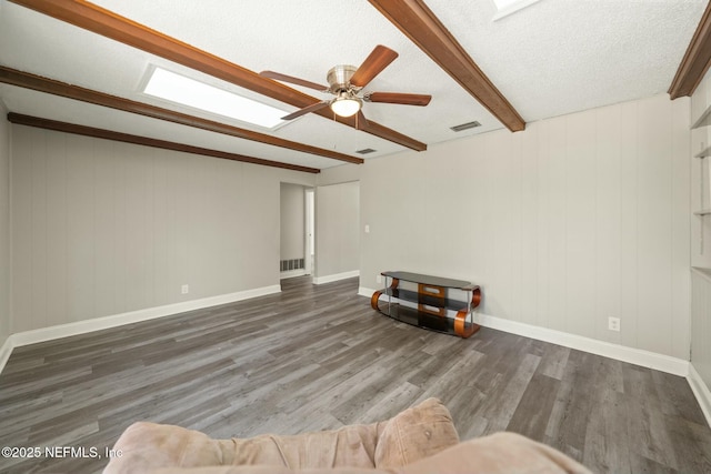 living room with ceiling fan, a textured ceiling, dark hardwood / wood-style flooring, and beam ceiling