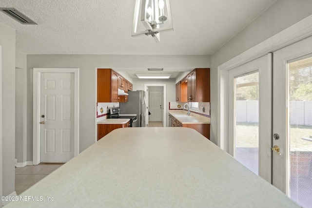 kitchen featuring hanging light fixtures, appliances with stainless steel finishes, sink, and a textured ceiling