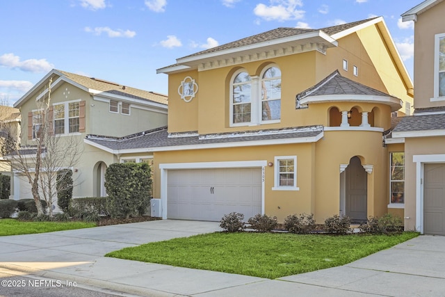 mediterranean / spanish home with a garage and a front lawn