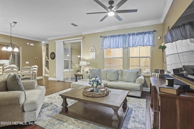 living room with crown molding, ceiling fan with notable chandelier, and dark hardwood / wood-style floors