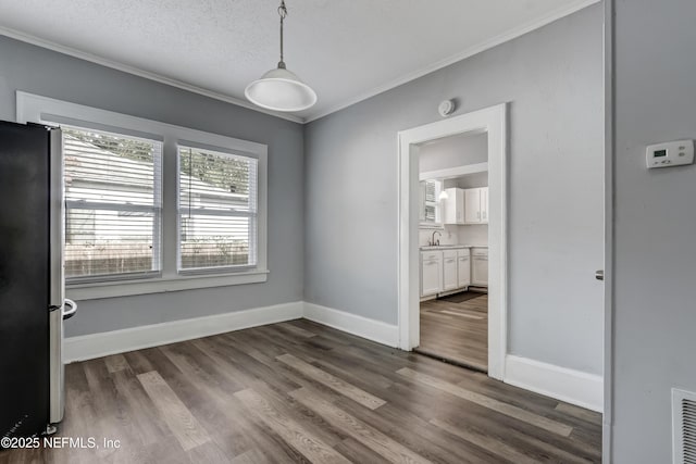 empty room featuring dark hardwood / wood-style flooring, crown molding, and a textured ceiling