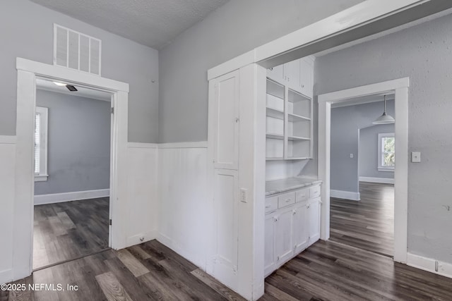 hallway featuring a textured ceiling and dark hardwood / wood-style floors