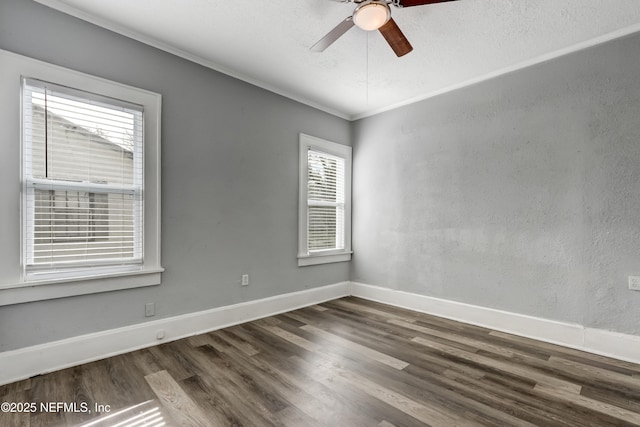 spare room featuring ceiling fan, dark wood-type flooring, and crown molding