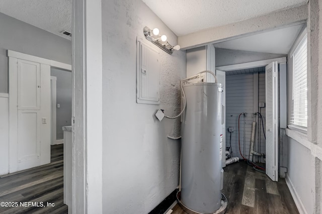 bathroom with a textured ceiling, electric water heater, vaulted ceiling, hardwood / wood-style flooring, and electric panel