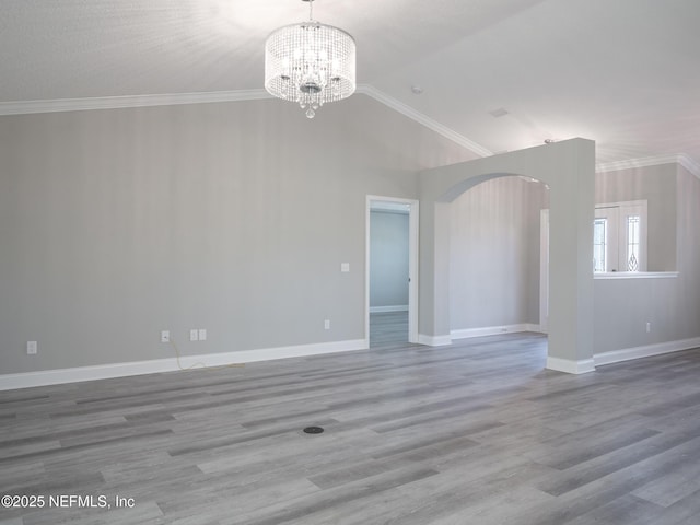 unfurnished living room with an inviting chandelier, ornamental molding, and hardwood / wood-style floors