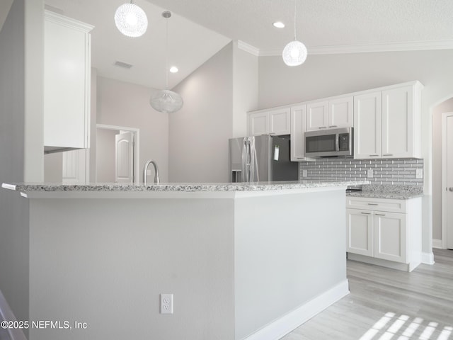 kitchen featuring decorative light fixtures, white cabinets, light stone counters, and appliances with stainless steel finishes