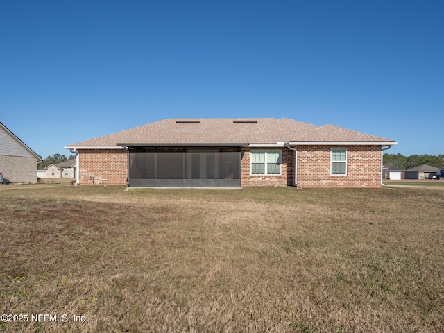 rear view of property with a yard and a sunroom