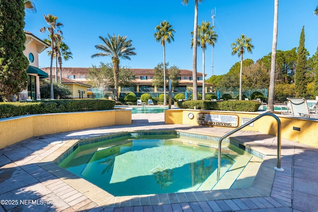 view of pool featuring a hot tub and a patio area