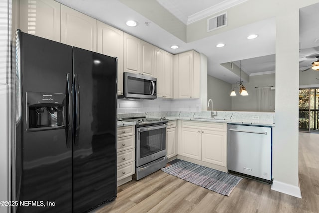 kitchen featuring stainless steel appliances, backsplash, crown molding, ceiling fan with notable chandelier, and sink