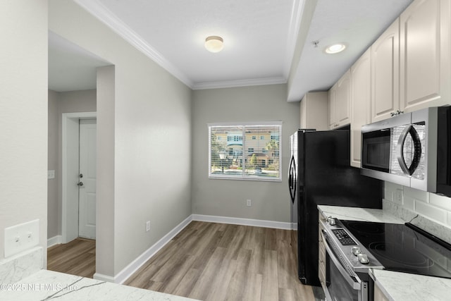 kitchen with white cabinetry, appliances with stainless steel finishes, light hardwood / wood-style flooring, and ornamental molding