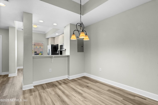 interior space with electric panel, light hardwood / wood-style flooring, ornamental molding, and a chandelier