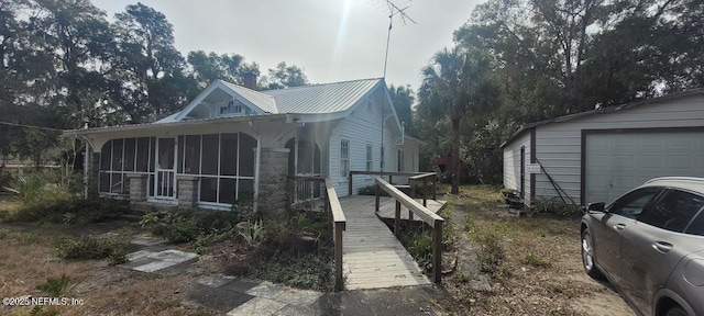 view of side of property with a garage and a sunroom