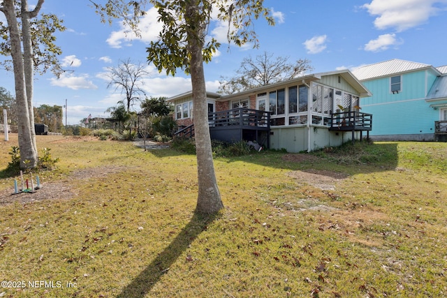 view of yard featuring a wooden deck and a sunroom