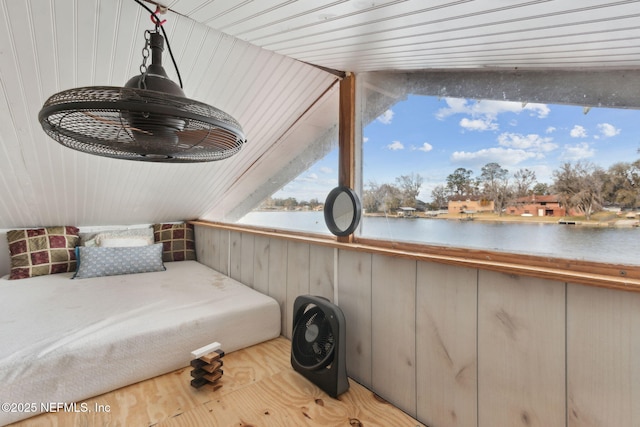 bedroom featuring wood finished floors and a water view