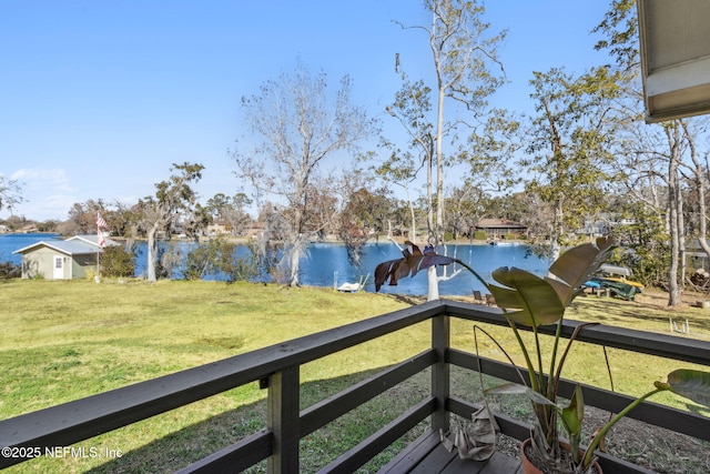 wooden terrace with a yard and a water view