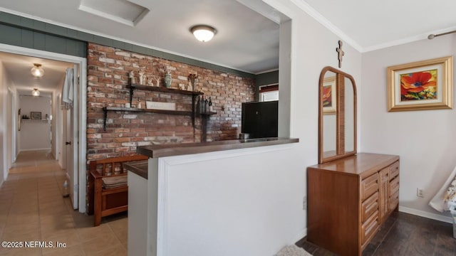 bar featuring tile patterned floors, bar area, brick wall, crown molding, and baseboards