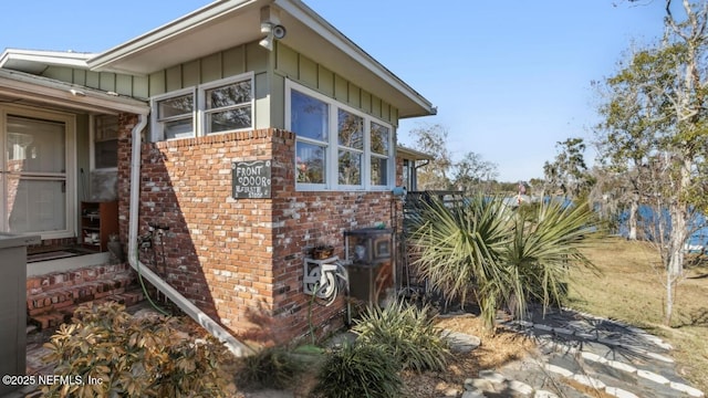 view of side of property with brick siding and board and batten siding