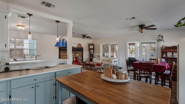 kitchen featuring a wealth of natural light, visible vents, open floor plan, and ceiling fan