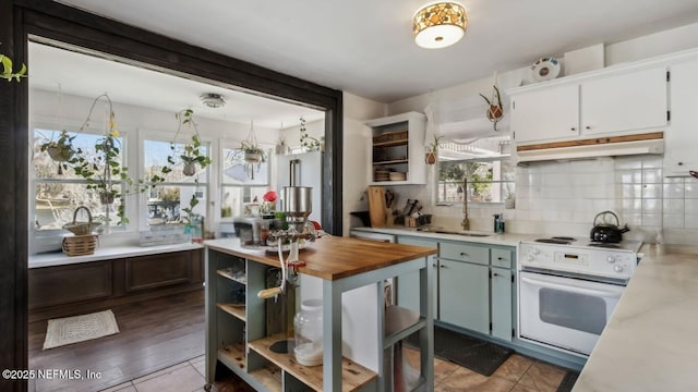 kitchen with open shelves, under cabinet range hood, decorative backsplash, white range with electric stovetop, and a sink