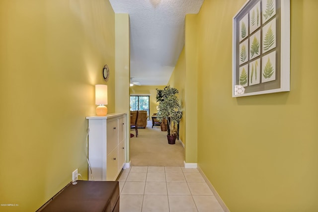 hallway featuring a textured ceiling and light colored carpet