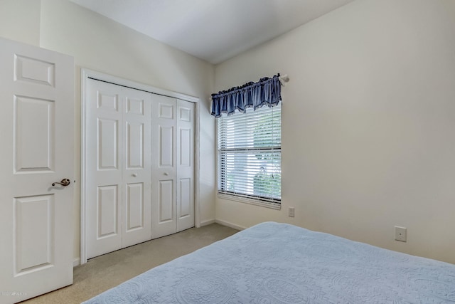 bedroom featuring a closet and light colored carpet