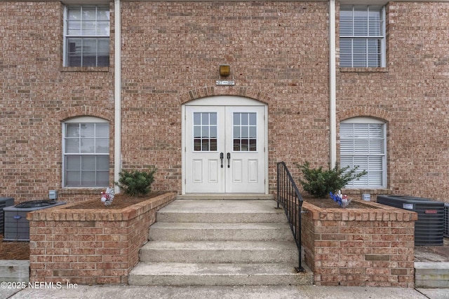 view of exterior entry featuring french doors and central AC