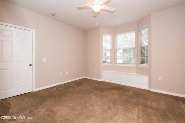 carpeted spare room featuring baseboards and ceiling fan