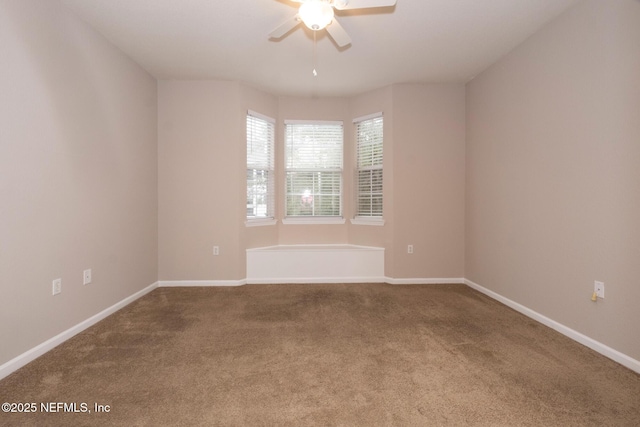 empty room featuring carpet flooring, a ceiling fan, and baseboards