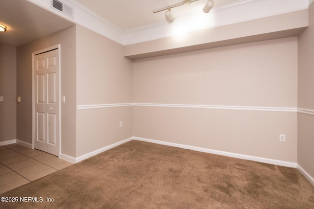 basement with crown molding, light tile patterned flooring, and track lighting