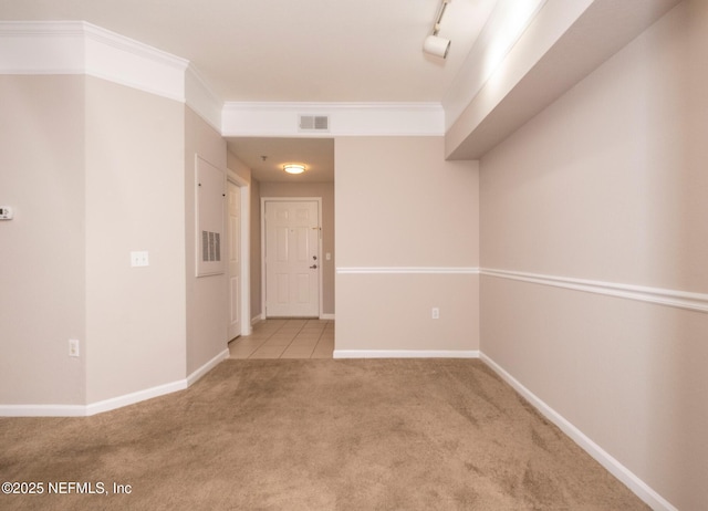 empty room featuring ornamental molding and light colored carpet