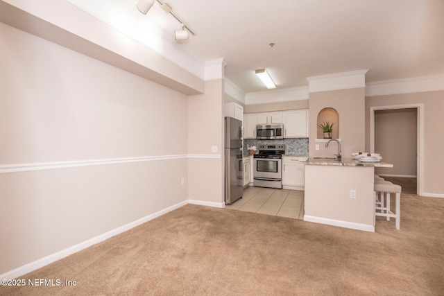 kitchen featuring white cabinetry, sink, a kitchen breakfast bar, stainless steel appliances, and light carpet