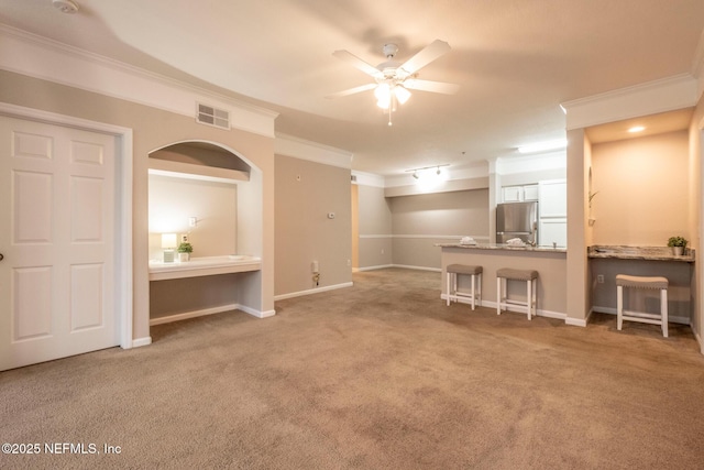 living area with carpet, baseboards, visible vents, ceiling fan, and ornamental molding