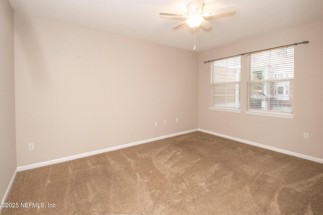 empty room with carpet flooring, ceiling fan, and baseboards