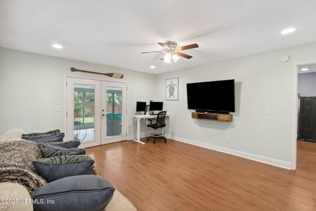 living room with ceiling fan, french doors, a textured ceiling, and hardwood / wood-style floors