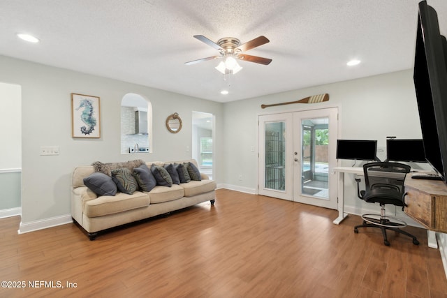 office area featuring ceiling fan, a textured ceiling, french doors, and light wood-type flooring