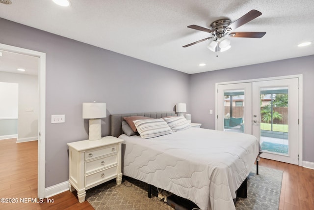 bedroom featuring ceiling fan, access to exterior, hardwood / wood-style floors, a textured ceiling, and french doors